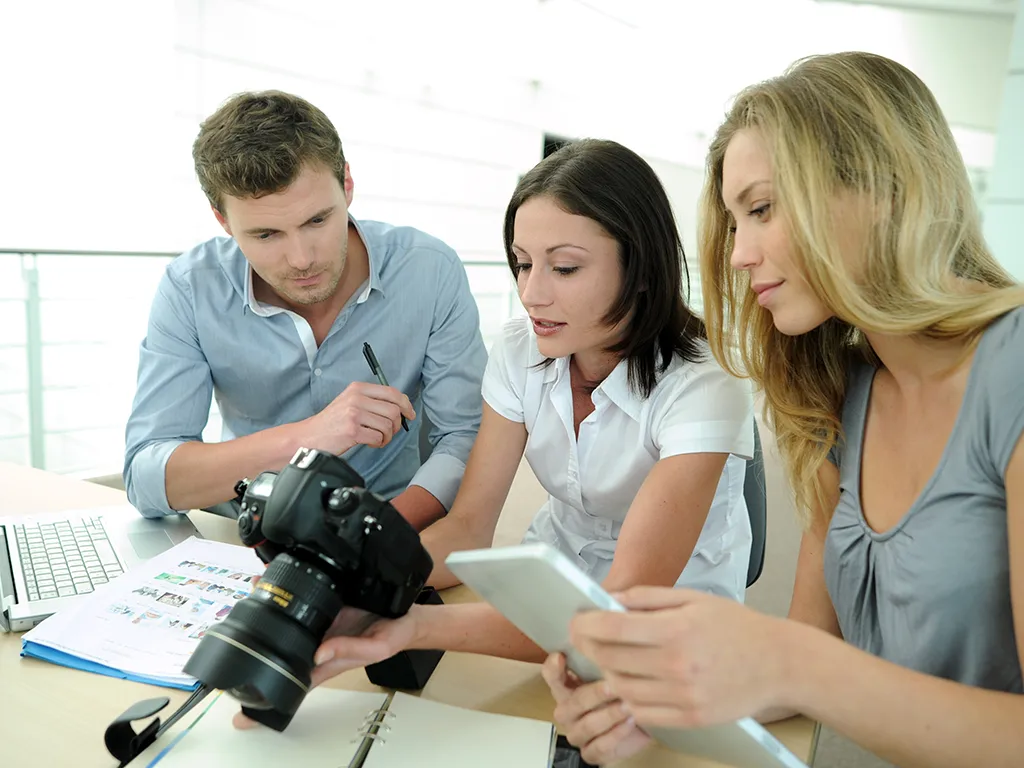 Zespól fotografów analizuje zdjęcie w aparacie