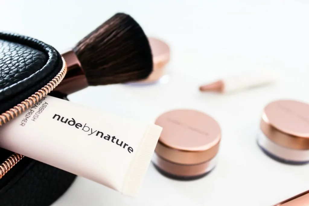 Lekki podkład krem BB do twarzy na letnie dni, w tle pędzel do pudru