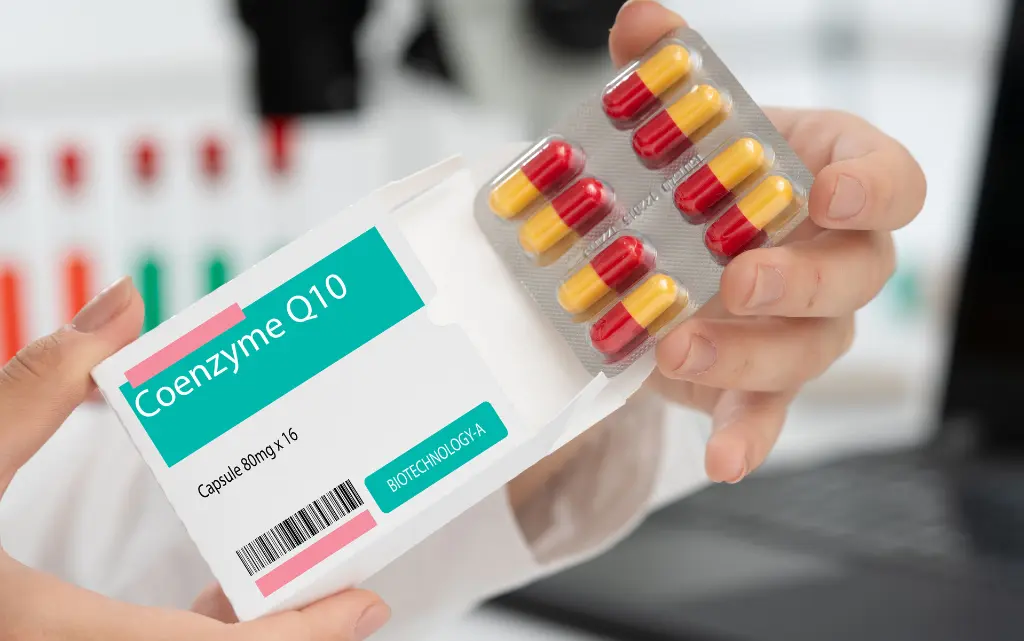 Farmaceuta trzyma opakowaniu koenzymu Q10 w tabletkach